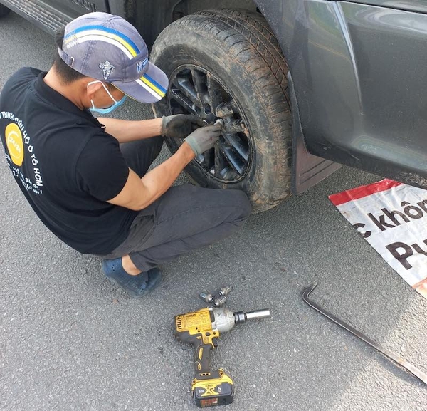 Nhân viên kỹ thuật hỗ trợ khách hàng gặp vấn đề với lốp ô tô